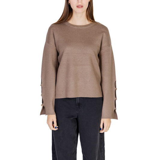 Person wearing a brown sweater and black pants on a white background